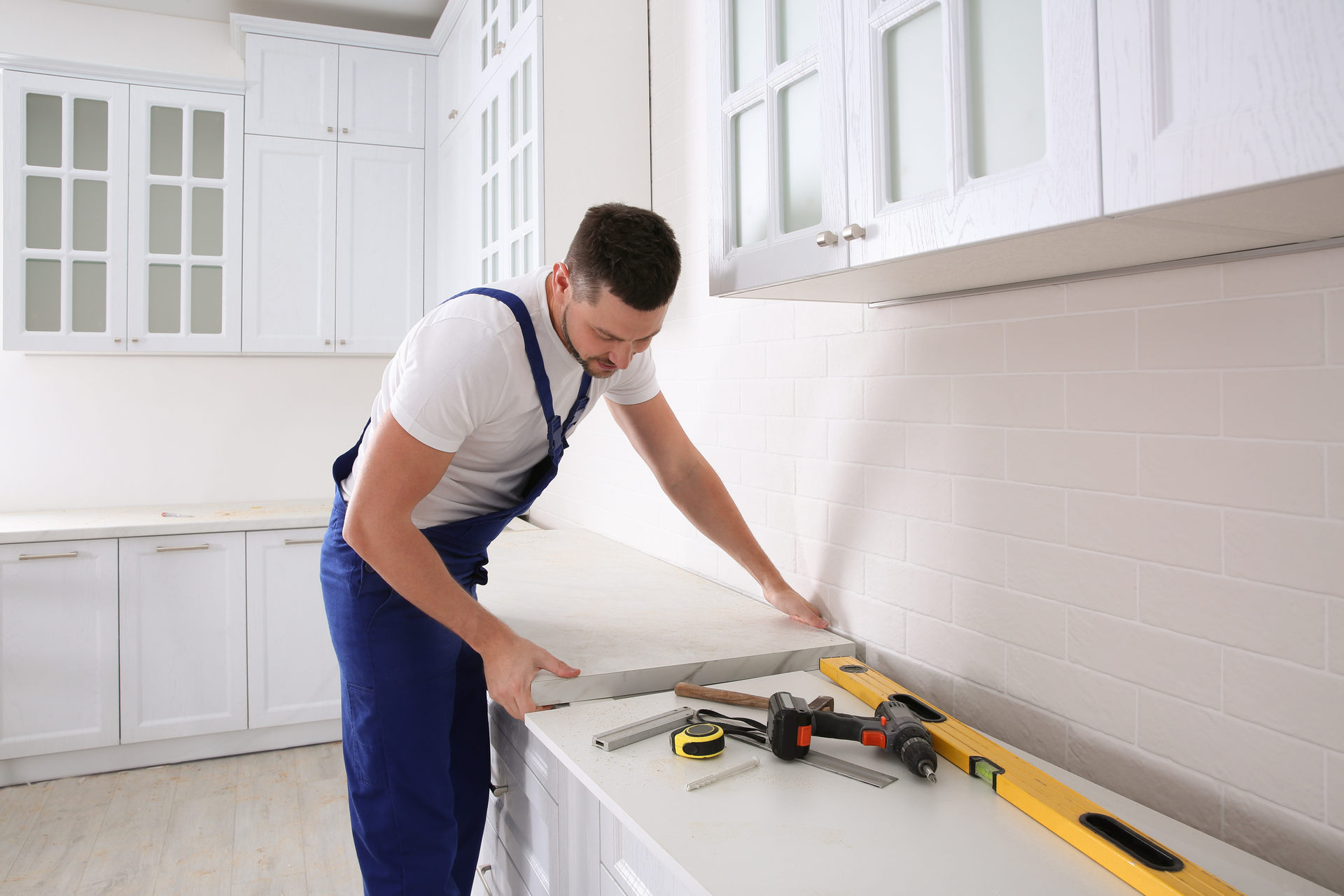 Worker,Installing,New,Countertop,In,Modern,Kitchen